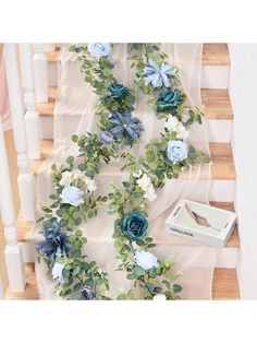 blue flowers and greenery are on the stairs