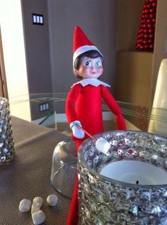 an elf is holding a spoon in front of a tin can filled with marshmallows