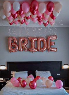 balloons and streamers are on the bed for a bride's day party in this bedroom