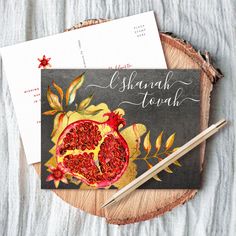 two greeting cards with pomegranates on them, one has a pencil and the other has an envelope