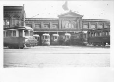 an old black and white photo of trolleys in front of a building