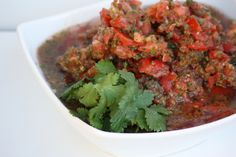 a white bowl filled with food and garnished with cilantro on top