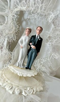 a wedding cake topper with a bride and groom on it