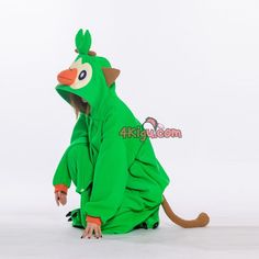 a person in a green animal costume sitting on the ground