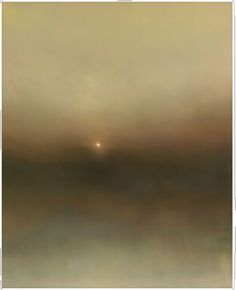 a blurry photo of the sun setting over water with fog in the air above it