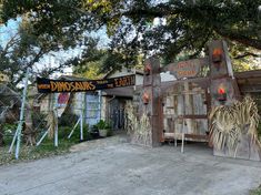 the entrance to an amusement park with wooden gates and signs on it's sides