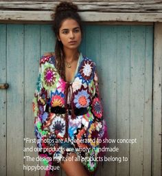 a woman standing in front of a wooden door wearing a colorful dress with flowers on it