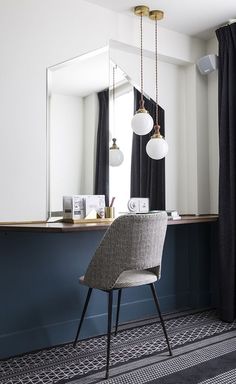 a chair sitting in front of a mirror on top of a counter next to a window