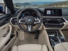 the interior of a bmw vehicle with dashboard, steering wheel and infotains on display