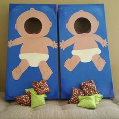 two blue bags with babies on them sitting on a chair in front of a wall