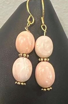 Stunning genuine Mexican opal beads with pearl finish make these earrings. They are 6x8mm ovals that have different patterns on each side. They are accented with gold tone Bali spacers. The earrings are 1 inch long, not including ear wires. Gold Oval Pink Opal Jewelry, Oval Gold Jewelry With Pink Opal, Oval Pink Opal Gold Jewelry, Mexican Opal, Raku Pottery, Labradorite Bracelet, Opal Beads, Celtic Cross, Opal Earrings