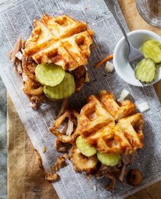 two waffle sandwiches with pickles on top