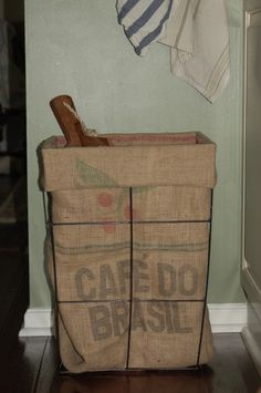 a bag that is sitting on the floor next to a wall with clothes hanging from it