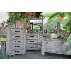 a bedroom with a bed, dresser and mirror in the middle of an outdoor area