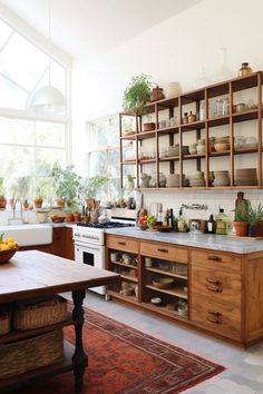 a kitchen filled with lots of wooden cabinets and counter top space next to a dining room table