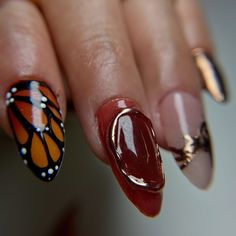 a woman's hand with a butterfly nail art design on it and a red manicure