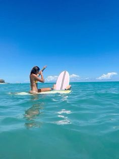 a woman riding on top of a surfboard in the ocean