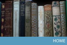 a row of old books sitting on top of a book shelf next to each other