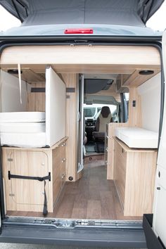 the interior of an rv with wood paneling and white walls, including storage compartments