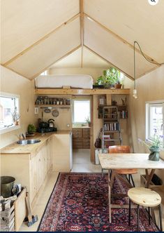 the interior of a tiny house with a table and chairs in it, next to a kitchen