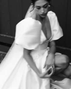 a woman in a wedding dress kneeling down