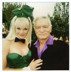 a man standing next to a woman wearing a green dress and bow tie on her head