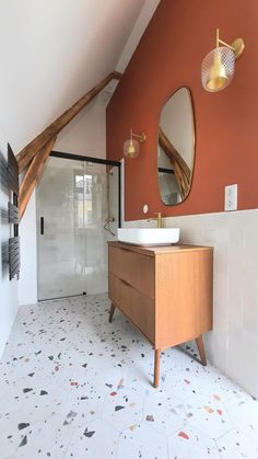 a bathroom with an orange wall and white floor