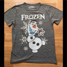 a frozen t - shirt on a wooden floor with snowflakes and an orange nose