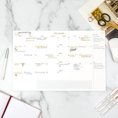 a calendar sitting on top of a table next to a cup of coffee and pencils