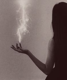 a woman is holding out her hand with a lightening bolt in the air above her