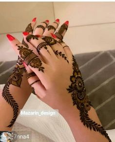 a woman's hands with henna tattoos on them