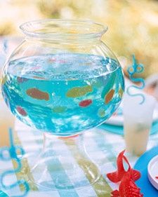 a fish bowl filled with blue liquid on top of a table