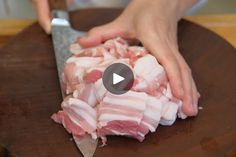 a person cutting up meat on top of a wooden table