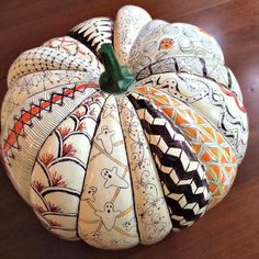 a decorative pumpkin sitting on top of a wooden table