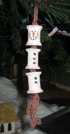 a snowman ornament hanging from a christmas tree