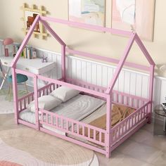 a child's bed with a pink frame and mattress in a room that looks like a doll house