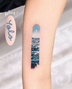 a person with a tattoo on their arm that has an image of the ocean in it