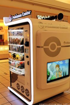 a vending machine in the middle of a shopping mall with pokemon games on it