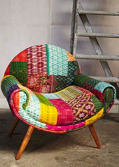 a multicolored chair sitting in front of a ladder