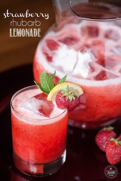 strawberry rhubarb lemonade is garnished with ice and fresh strawberries