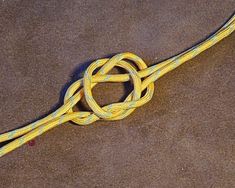 a yellow rope laying on the ground with it's end in the middle of it