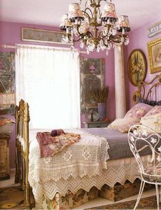 a bed room with a neatly made bed and a chandelier hanging from the ceiling