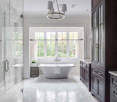 a large white bath tub sitting in a bathroom next to a walk - in shower