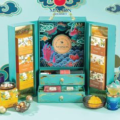 an assortment of teas and other items in a display case on a blue background