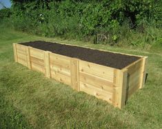 a wooden raised garden bed with soil in it