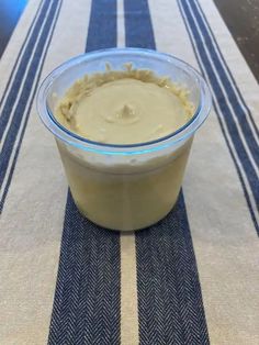 a bowl of food sitting on top of a blue and white striped table cloth next to a fork