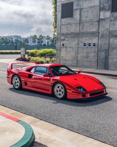 a red sports car driving down the street