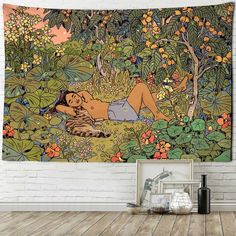 a woman laying on the ground in front of flowers and trees tapestry hanging on a wall