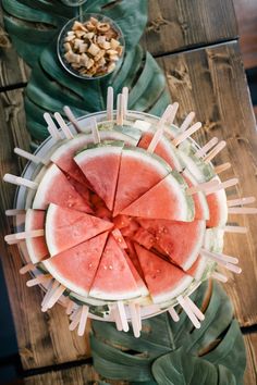 slices of watermelon are arranged in a bowl on a table with other food items