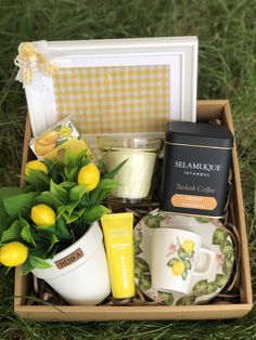 a box filled with tea, lemons and other items sitting on the green grass